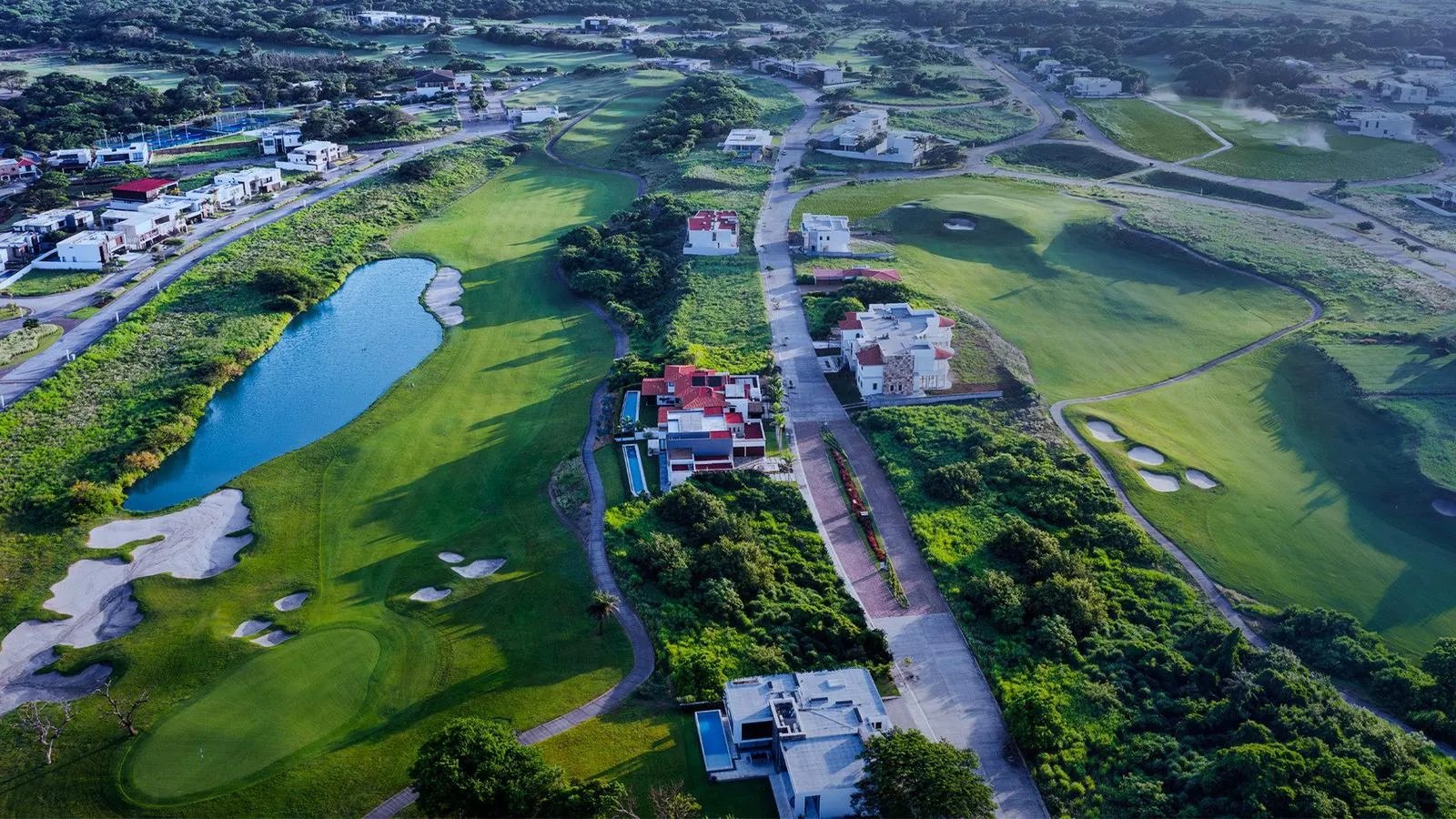 Vista aérea del desarrollo Punta Tiburón, con campo de golf, laguna y residencias de AGCA